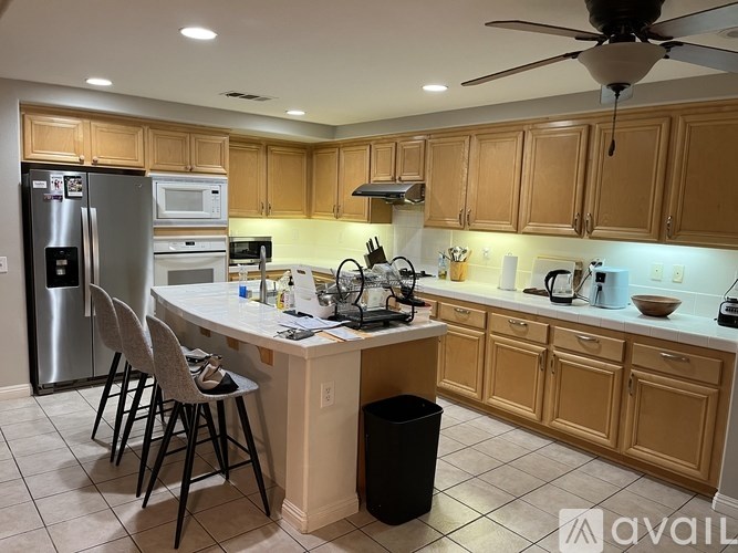 A kitchen with wooden cabinets and a white island.