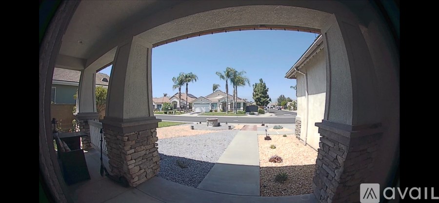 A view from a house through an archway looking out to a street.