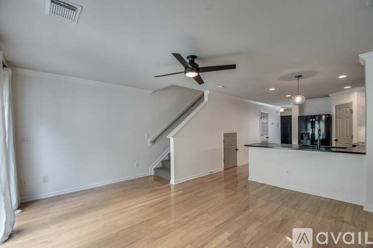A spacious living room with a staircase leading to the upper floor.