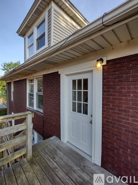 A house with a white door and a wooden deck.