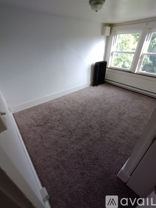 A room with a carpeted floor and a window.