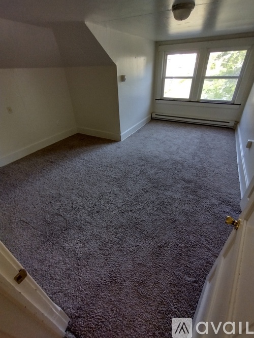 A room with a carpeted floor and a window.