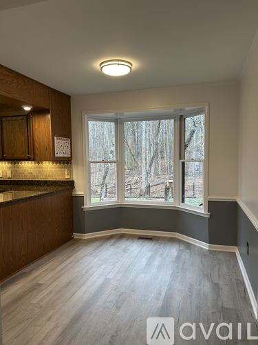 A room with a window showing trees outside.