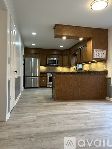 A kitchen with wooden cabinets and a refrigerator.