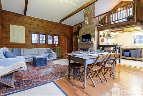 A cozy living room with a fireplace and a dining table set for a meal.