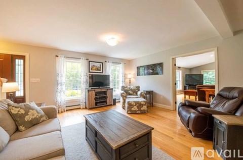 A living room with a grey couch and a brown leather chair.