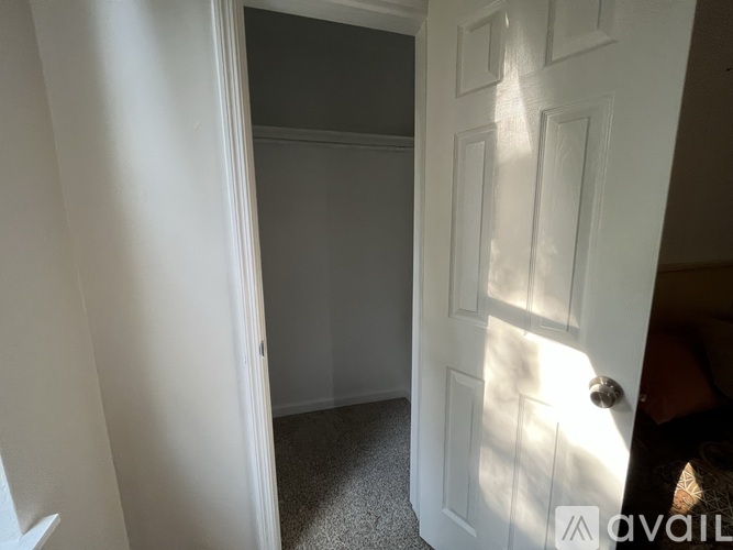A white door is open to a dark room.