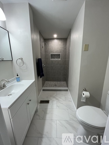 A bathroom with a toilet, sink, and shower.