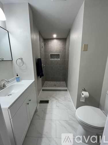 A bathroom with a toilet, sink, and shower.