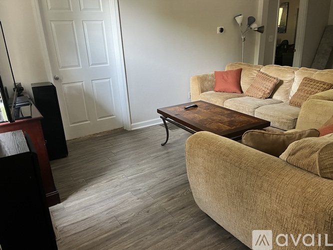 A living room with a couch, a coffee table, and a television.