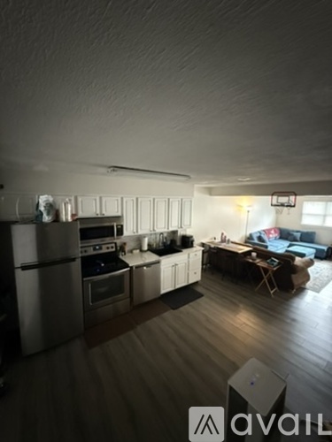 A kitchen with a refrigerator, oven, and sink.