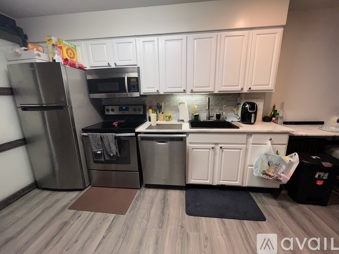 A kitchen with white cabinets and a wooden floor.