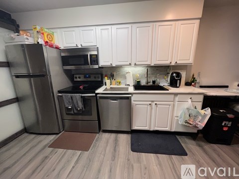 A kitchen with white cabinets and a wooden floor.