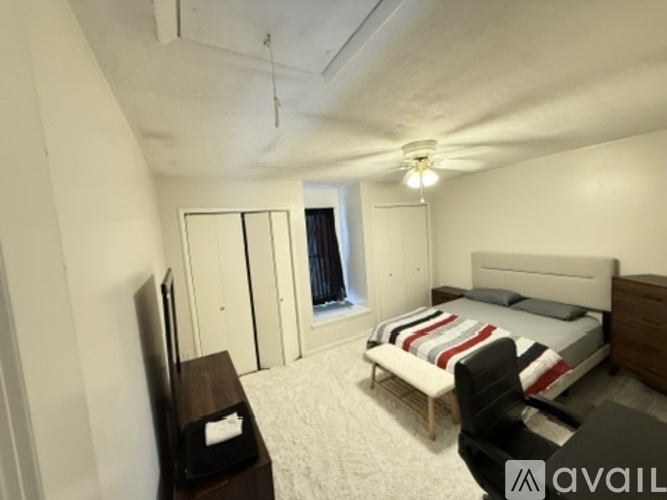 A bedroom with a bed, chair, and television.