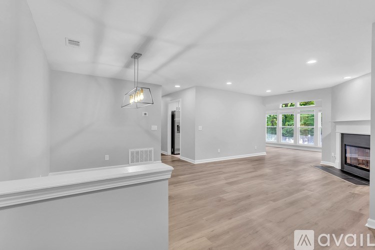 A modern living room with a fireplace and a large window.