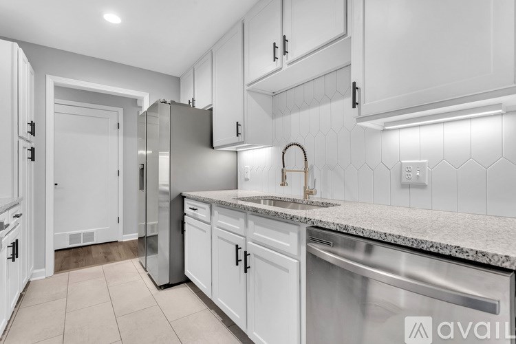 A kitchen with white cabinets and a granite countertop.
