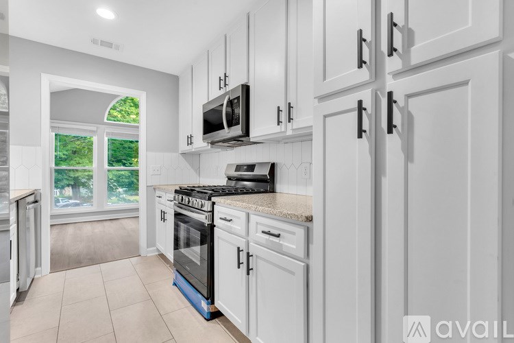 A kitchen with white cabinets and a black stove top.