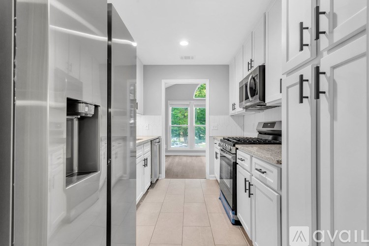 A modern kitchen with white cabinets and stainless steel appliances.