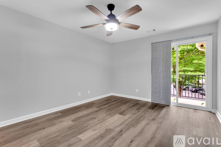 A room with a ceiling fan and wooden flooring.