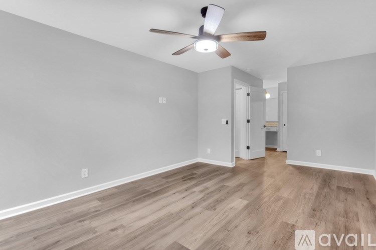 A room with a ceiling fan and wooden flooring.