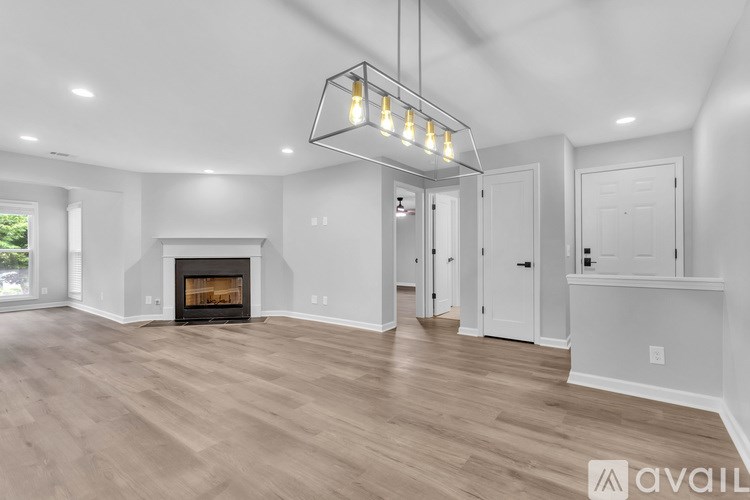 A modern living room with a fireplace and a chandelier.