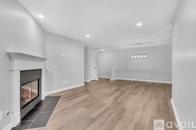 A spacious living room with a fireplace and hardwood floors.