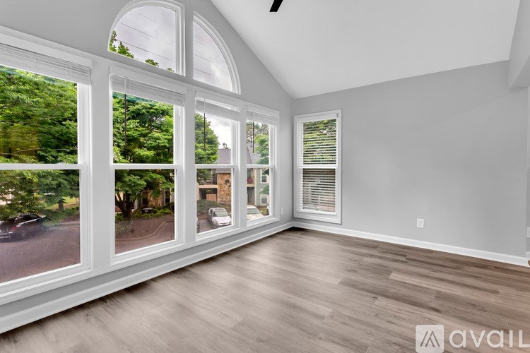 A room with a large window and wooden flooring.