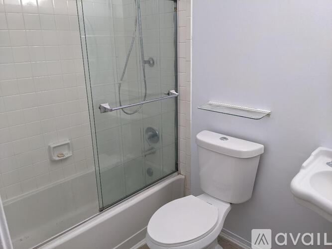 A white toilet sits next to a glass shower stall in a bathroom.