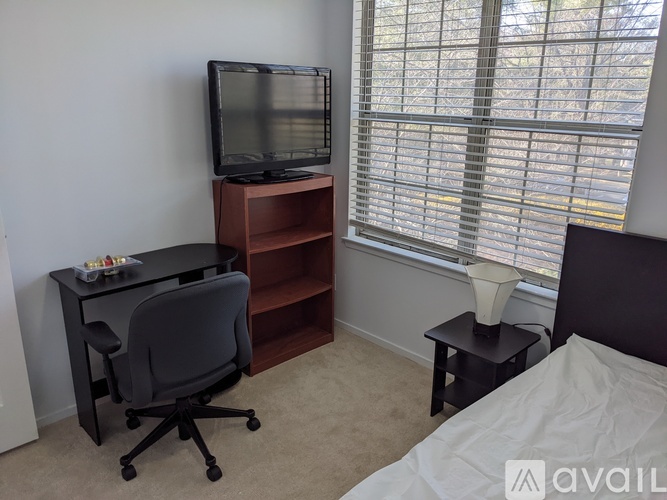A living room with a brown leather couch, a wooden coffee table, and a flat screen TV.