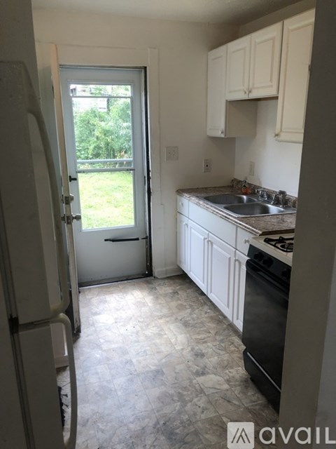 A kitchen with a black stove and white cabinets.