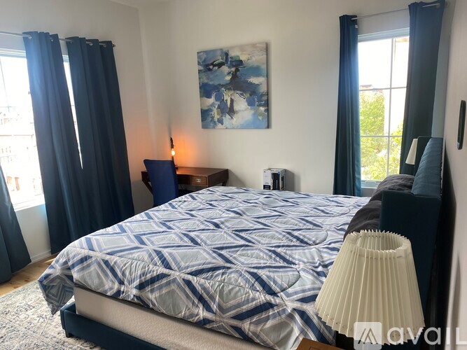 A bedroom with a large bed and a painting on the wall.