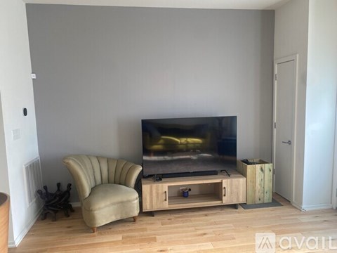 A living room with a television and a chair.