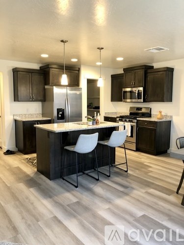 A kitchen with a white countertop and black cabinets.