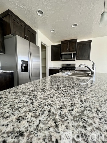 A kitchen with granite countertops and stainless steel appliances.
