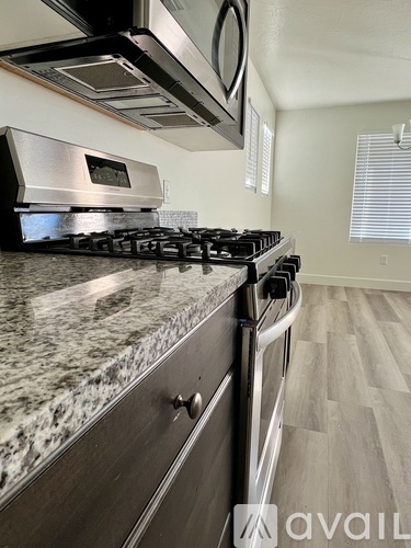 A modern kitchen with granite countertops and stainless steel appliances.