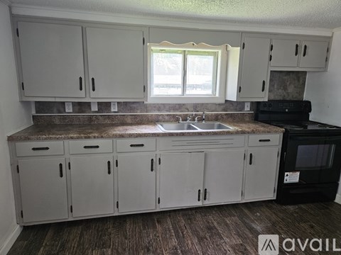 A kitchen with white cabinets and a brown countertop.