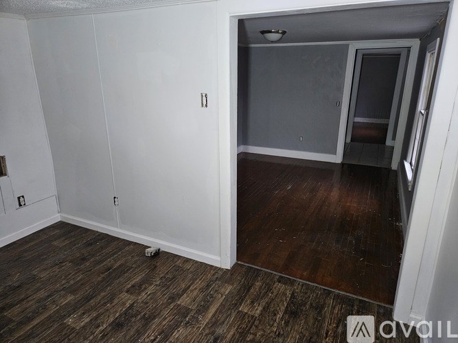 A room with a wooden floor and white walls.