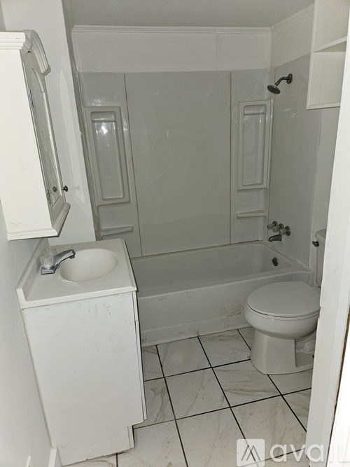 A white bathroom with a sink, toilet and bathtub.
