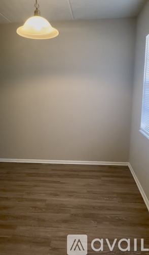 A room with wooden flooring and a light hanging from the ceiling.