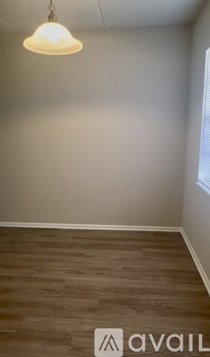 A room with wooden flooring and a light hanging from the ceiling.