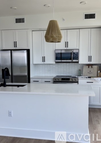 A kitchen with white cabinets and a white island.