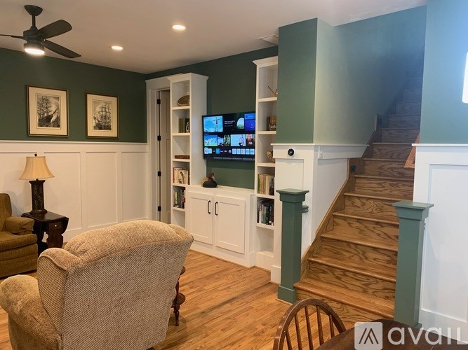 A living room with a chair, a lamp, and a television.
