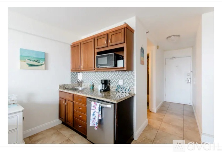 A kitchen with wooden cabinets and a black dishwasher.