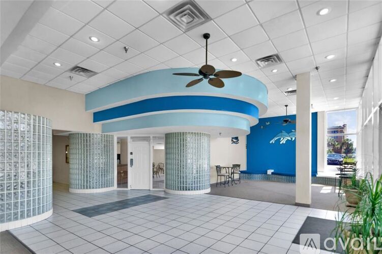 A spacious room with a fan and a blue wall.