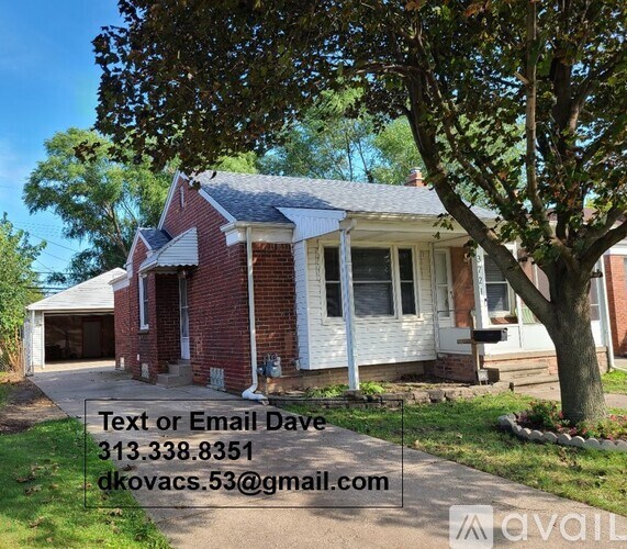 A red brick house with a white trim and a tree in front.
