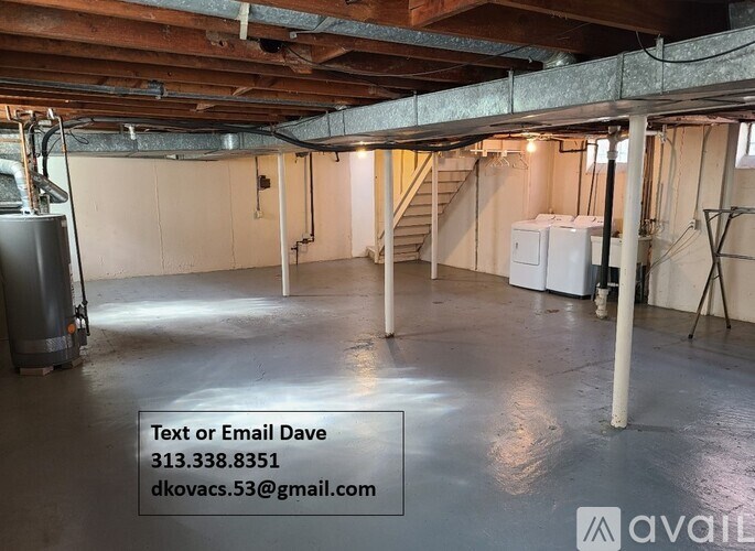 A spacious basement with a staircase, a refrigerator, and a washing machine.