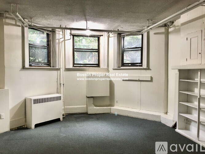 A room with a window and a radiator on the floor.