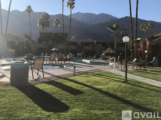 A pool area with chairs and a mountain in the background.