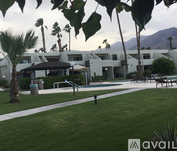A large white building with a pool in front of it.