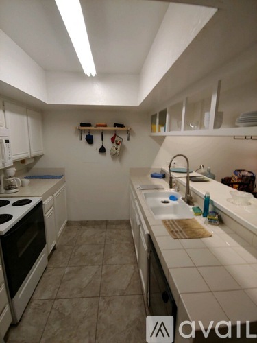 A kitchen with white cabinets and a white stove top oven.